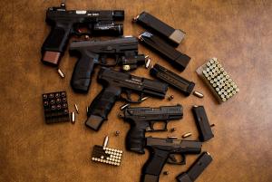 Verschiedene Waffen und Munition liegen auf einem Tisch - Waffenschein erforderlich