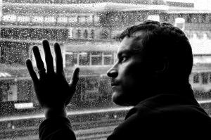 Ein Mann in einer psychischen Krise sieht aus dem Fenster.
