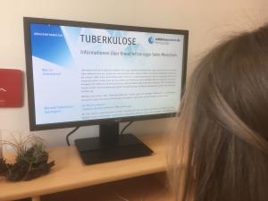 Junge Frau sitzt vorm PC und recherchiert über TBC