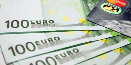 Mehrere EURO-Banknoten liegen aufgefächert und eine Kreditkarte