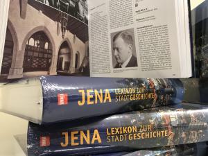 Bücherstapel "Jena. Lexikon zur Stadtgeschichte" mit historischem Bild im Hintergrund