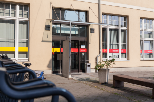 Blick auf den Sitz des Teams Bürgerservice von außen mit Bänken davor und dem Eingangsbereich