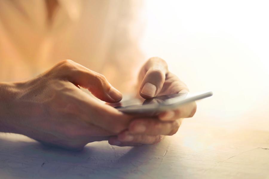 Hände halten ein Mobiltelefon